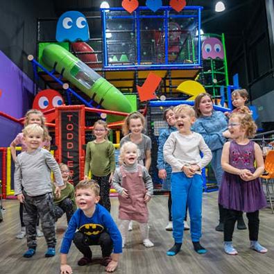 Group of young children laughing and smiling in soft play area
