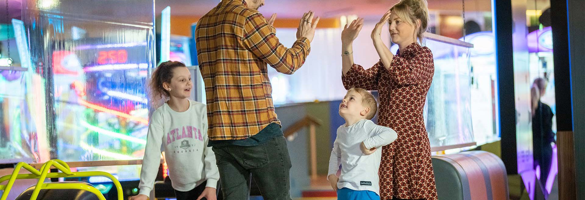 family having a great time and celebrating during a game of bowling at namco funscape