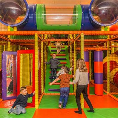 Group of young children playing in soft play area