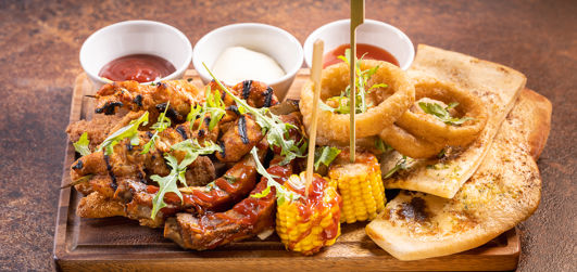 Southern fried chicken, BBQ riblets, chicken skewers, halloumi sticks, onion rings, grilled corn, garlic & rocket flatbread. With sweet chilli, BBQ & garlic mayo dips.