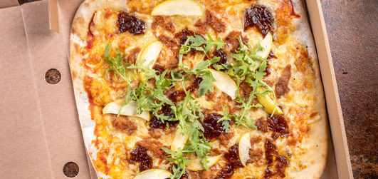 BBQ Pulled Pork pizza with BBQ pulled pork, Cheddar, Mozzarella, caramelised onion, fresh apple and rocket  in a pizza box