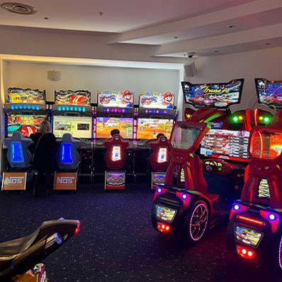 An arcade room filled with popular and classic driving simulation games