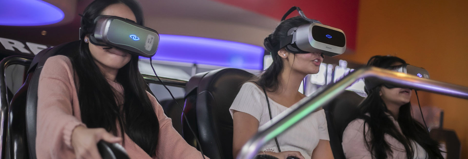 Three girls wearing virtual reality headsets