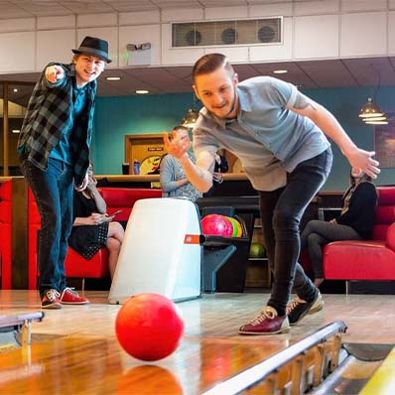 Two men playing a game of bowling and having a good time