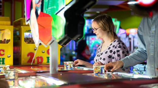 Woman smiling and playing with pushers at namco funscape