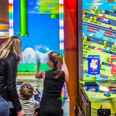 Mother and daughters playing flappy bird arcade game at Namco Funscape