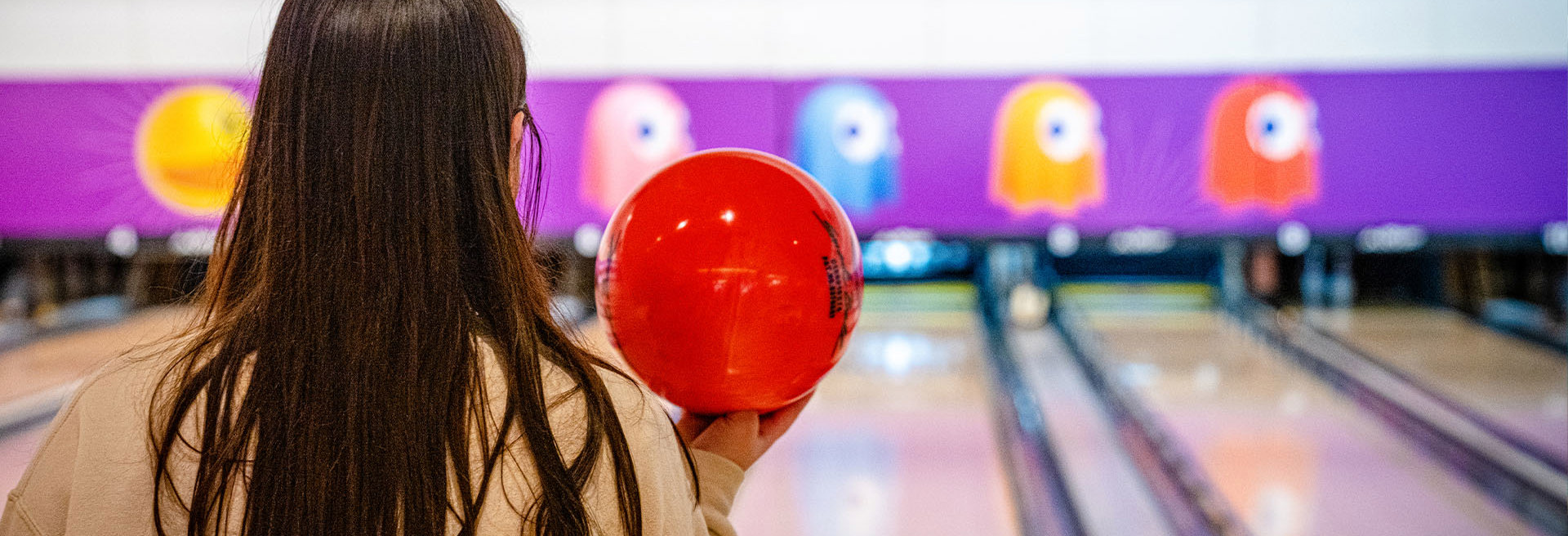 girl holding a bowling ball ready to bowl at namco funscape