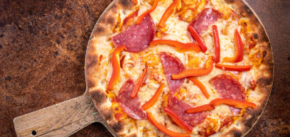 Pepperoni, with Bell peppers, Cheddar, Mozzarella, tomato sauce and rocket served on a pizza plate