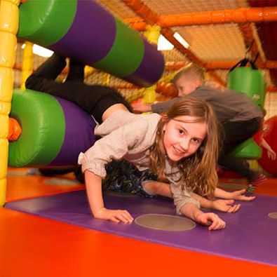 Young girl playing in soft play area