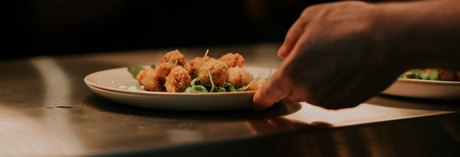 Chicken nuggets on a plate being taken to customer by restaurant staff