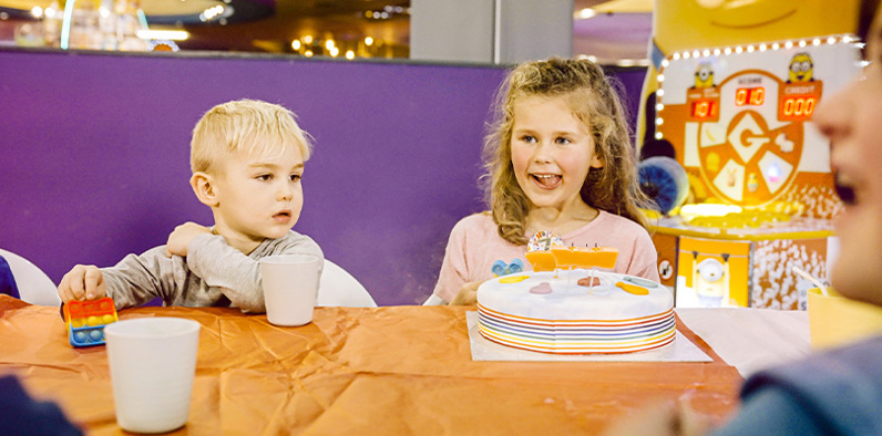Excited girl and boy celebrating with a birthday cake, surrounded by joy and festivity
