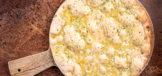 Garlic butter on pitta bread served on a pizza plate