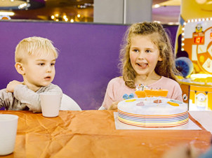 Excited girl and boy celebrating with a birthday cake, surrounded by joy and festivity