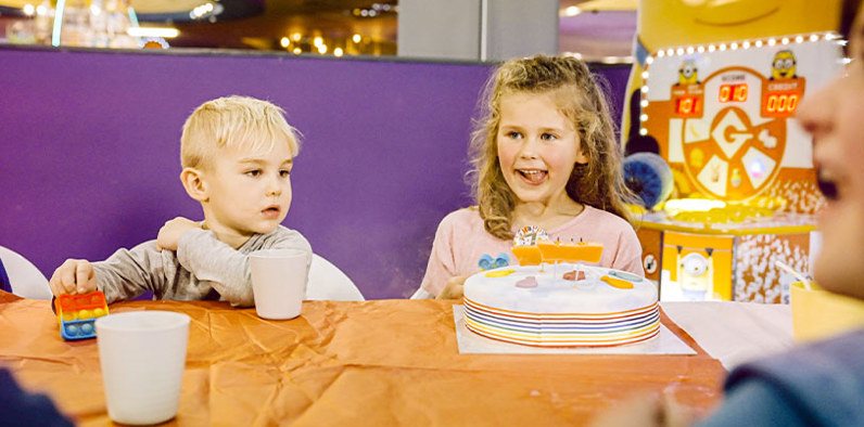 Excited girl and boy celebrating with a birthday cake, surrounded by joy and festivity