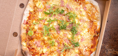 Classic Ham & Pineapple pizza with Cheddar, Mozzarella, ham, pineapple, tomato sauce and rocket in a pizza box
