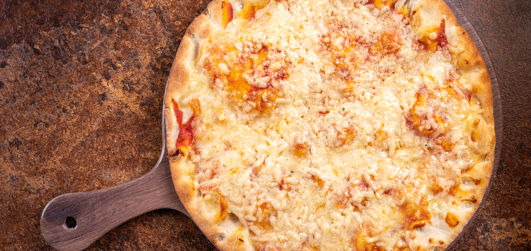 Margherita pizza with Cheddar, Mozzarella, tomato sauce and rocket on a pizza plate