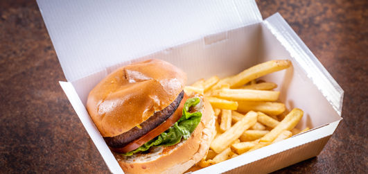 Burger with chips in a takeaway box