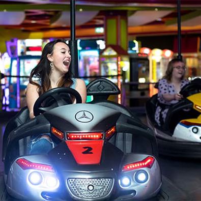 Young girl gleefully steering a dodgem car at Namco Funscape